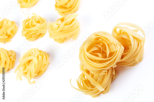 Italian rolled Raw noodles. Pasta on white background . Egg homemade dry ribbon noodles, long rolled macaroni or uncooked spaghetti isolated.