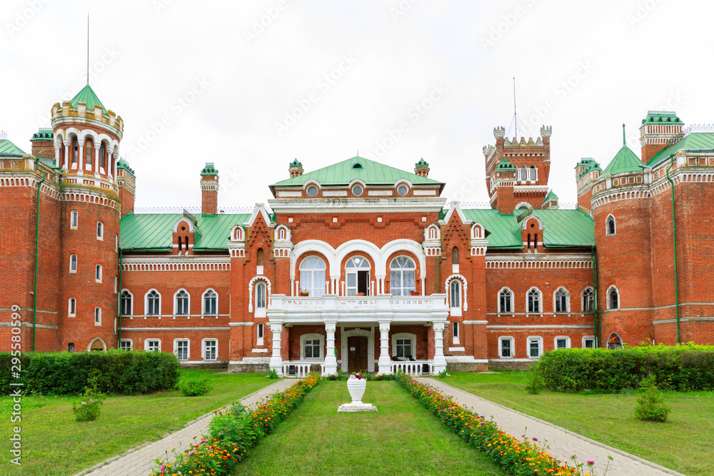 Fototapeta premium Sheremetev castle palace and park ensemble in the village of Yurino on the bank of the Volga, combination of different architectural styles in one building. Cloudy weather at the beginning of summer.