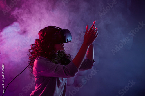 Virtual reality game. A girl in a virtual reality helmet plays a game or explores the environment.