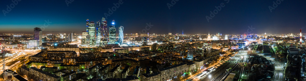 high-rise buildings and transport metropolis, traffic and blurry lights of cars on multi-lane highways and road junction at night in Moscow.