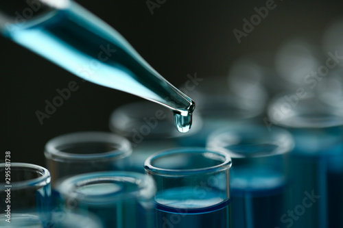 Test tube of glass overflows new liquid solution potassium blue conducts an analysis reaction takes various versions reagents using chemical pharmaceutics cancer manufacturing . photo