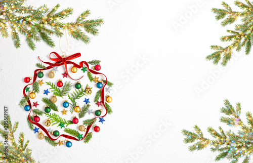 Christmas composition with red ribbon ,branches of fir tree and Christmas ornaments in shape of Christmas bauble on white background.
