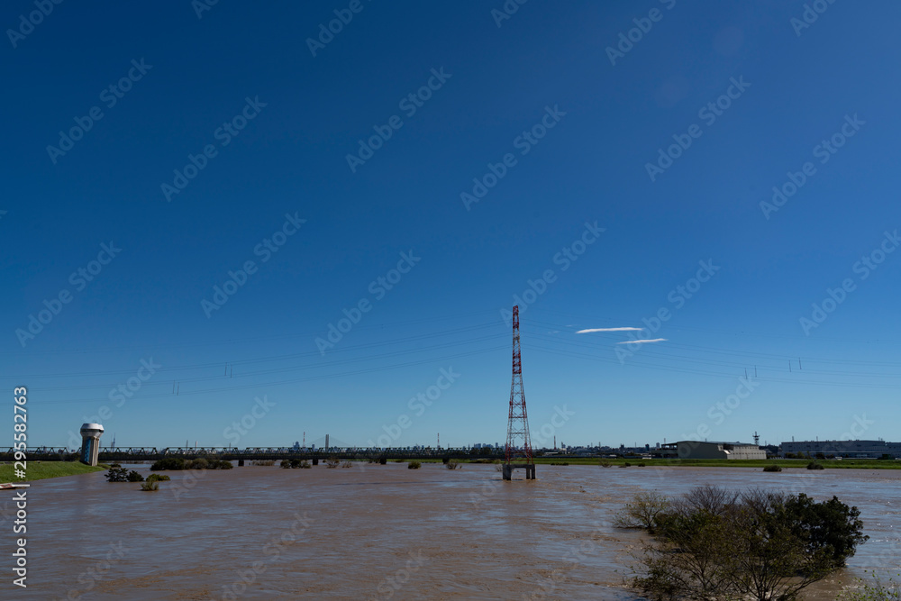台風で増水した荒川に沈む鉄塔