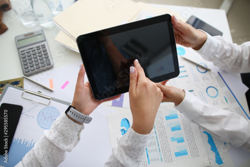 Fotografie Close-up of workers hands holding tablet and tapping screen