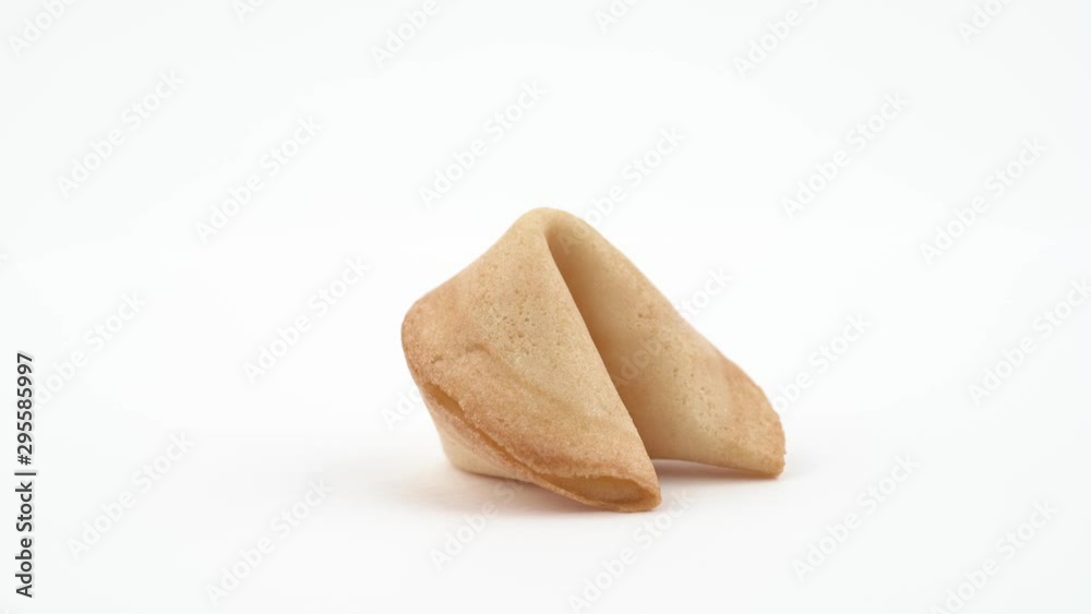 Close-up circling around shot of cookie with prediction spinning slowly on the table. Isolated, on white background. Close-up circling around shot of cookie with prediction spinning slowly on the table. Isolated, on white background.