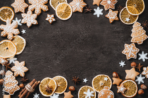 Christmas background with homemade gingerbread cookies on black table, copy space. Festive food, New Year celebration traditions