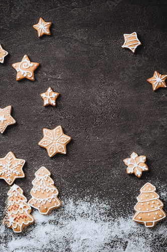 Christmas background with homemade gingerbread cookies on black table, copy space. Festive food, New Year celebration traditions