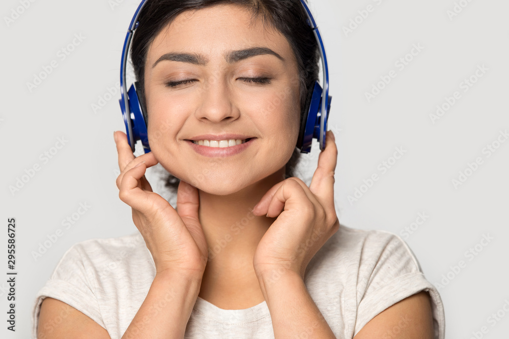 Smiling ethnic girl enjoy music in Bluetooth headphones Smiling ethnic girl enjoy music in Bluetooth headphones