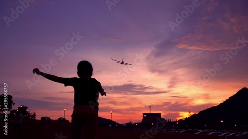 Silhouette kids playing aeroplane toy in sunset,slow-motion photo
