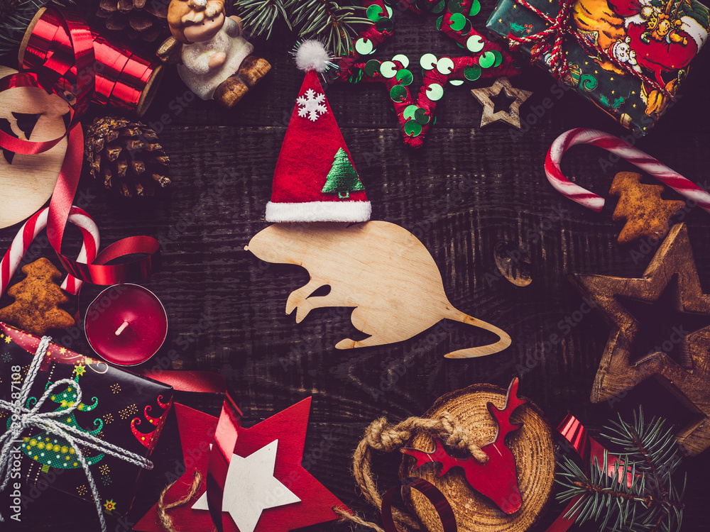 Wooden figure of a rat and Christmas decorations. View from above, close-up, flat lay. Congratulations to loved ones, family, relatives, friends and colleagues