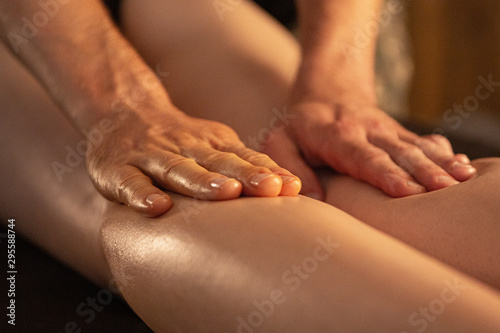 masseur massages the legs of a beautiful girl