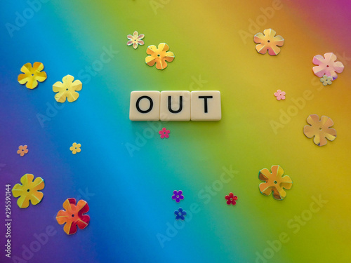 Bright rainbow colored background sign with the word "OUT" in text lettering, for a vivid and eye catching sign, banner, graphic, poster or placard