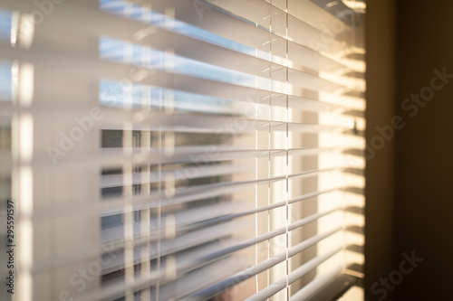 Sunlight coming through venetian blinds by the window