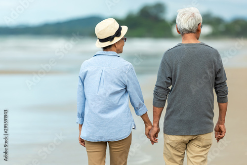 Lifestyle asian senior couple happy walking and relax on the beach.  Tourism elderly family travel leisure and activity after retirement in vacations and summer.