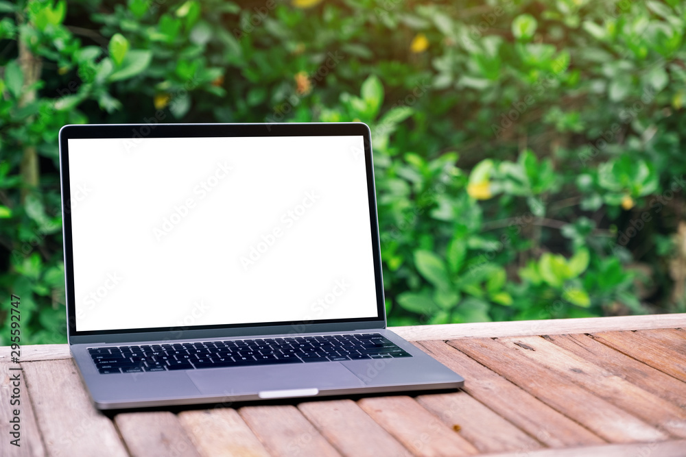 Mockup image of laptop computer with blank white desktop screen on wooden table Mockup image of laptop computer with blank white desktop screen on wooden table