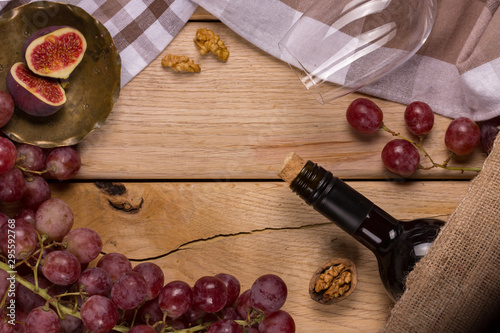 Flat with a thunderstorm of red grapes, a bottle of wine, a glass and figs