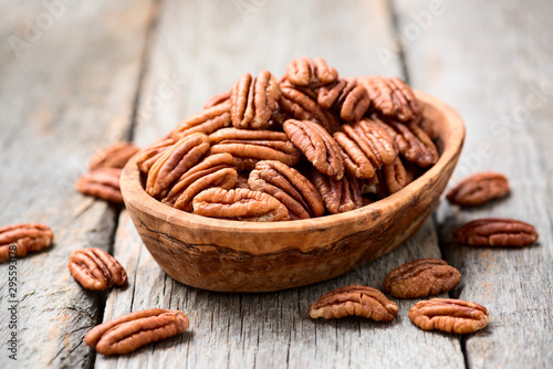 Tasty peeled pecan nuts in wooden bowl. photo