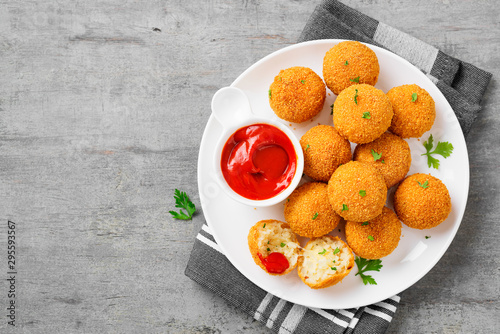 Homemade Fried Risotto Arancini stuffed with cheese, served with tomato sauce.