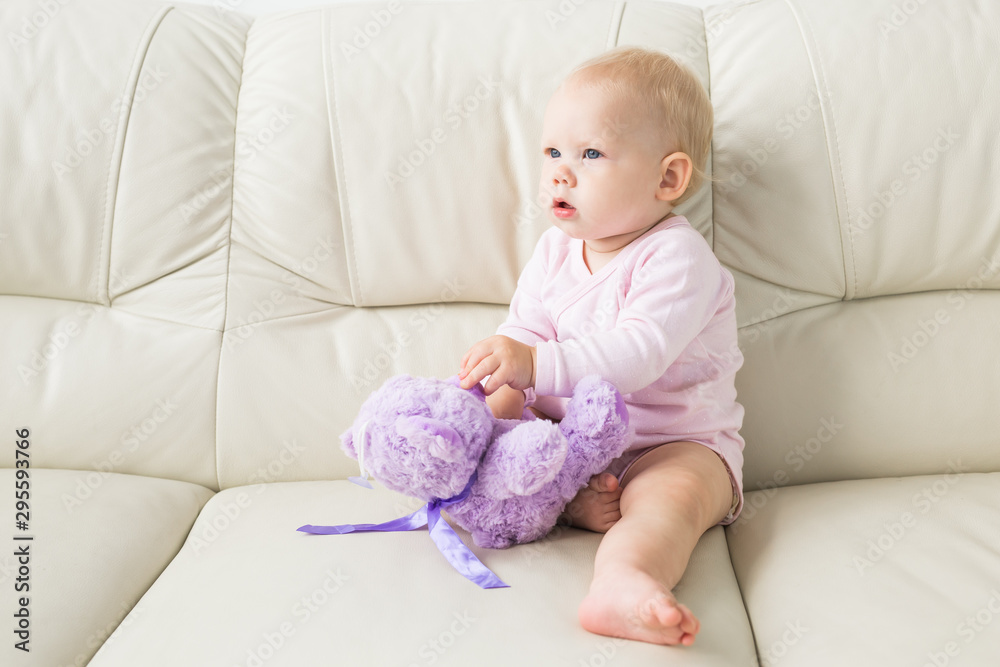 Children, infant and childhood concept - Beautiful cute soft baby sitting on sofa Children, infant and childhood concept - Beautiful cute soft baby sitting on sofa