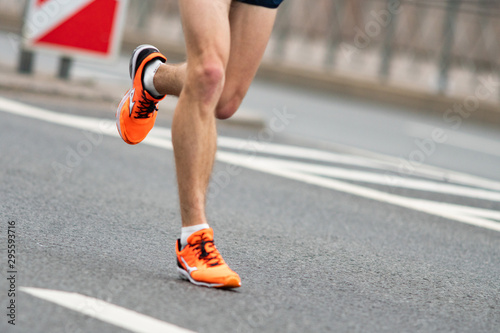 Closeup of the feet of a runner. A man runs on the asphalt