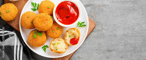 Homemade Fried Risotto Arancini stuffed with cheese, served with tomato sauce.