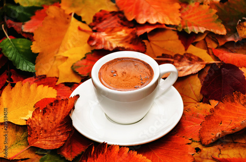 Autumn composition. Cup of coffee on colorful autumn leaves. Creative autumn thanksgiving, fall, halloween concept