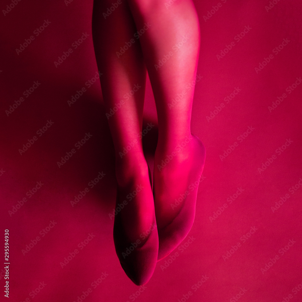 photo female legs down in pink tights on a pink background photo female legs down in pink tights on a pink background