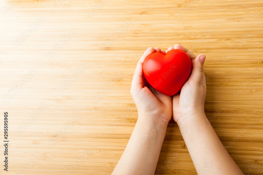 child hands holding red heart, health care, donate and family insurance concept child hands holding red heart, health care, donate and family insurance concept