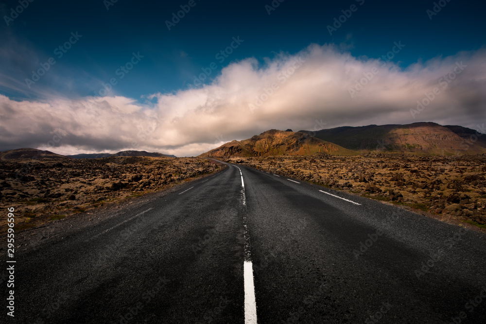 An empty Icelandic road leads through a mountain range