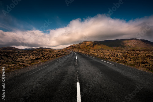 Obraz na płótnie An empty Icelandic road leads through a mountain range w salonie