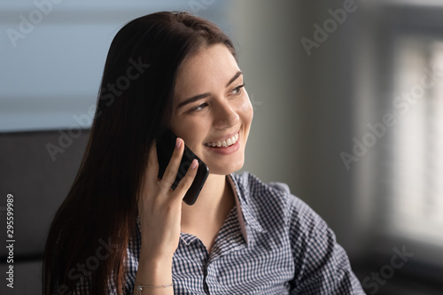 Head shot close up young happy woman holding call with partners. © fizkes