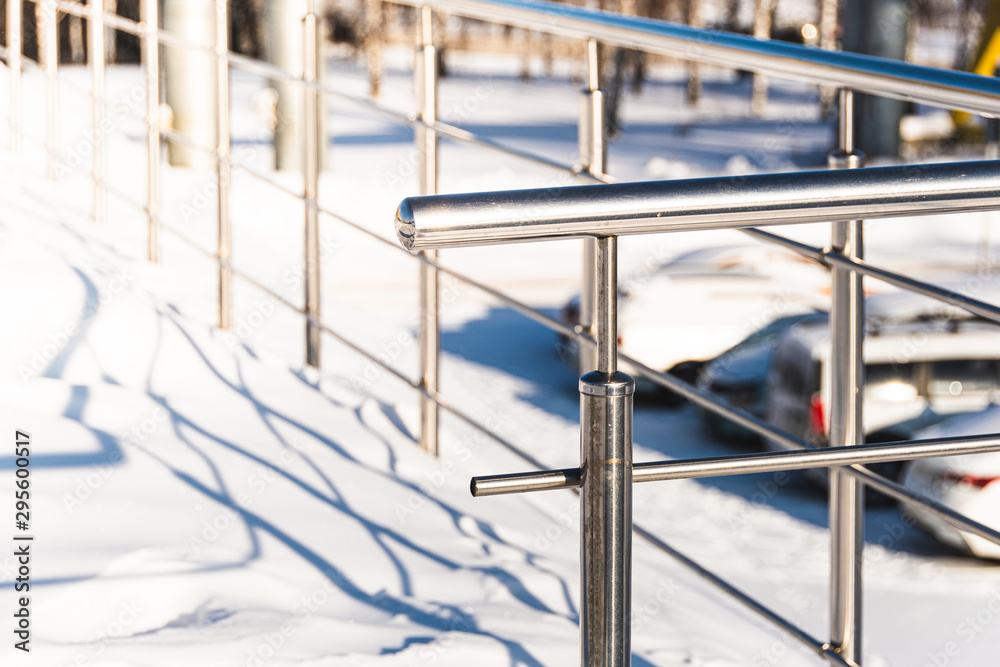 Metal handrail on winter stairs. Dangerous stairs under snow, safe handrail.