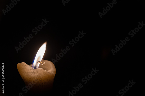 lonely memorial candle. Candle flame burns in dark