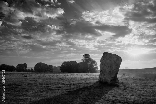 Stunning  black and white Summer sunrise landscape of Neolithic standing stones in English cluntryside with gorgeous light with slight background mist © veneratio