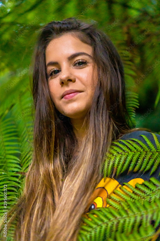 Look of a young brunette tucked into green plants Look of a young brunette tucked into green plants