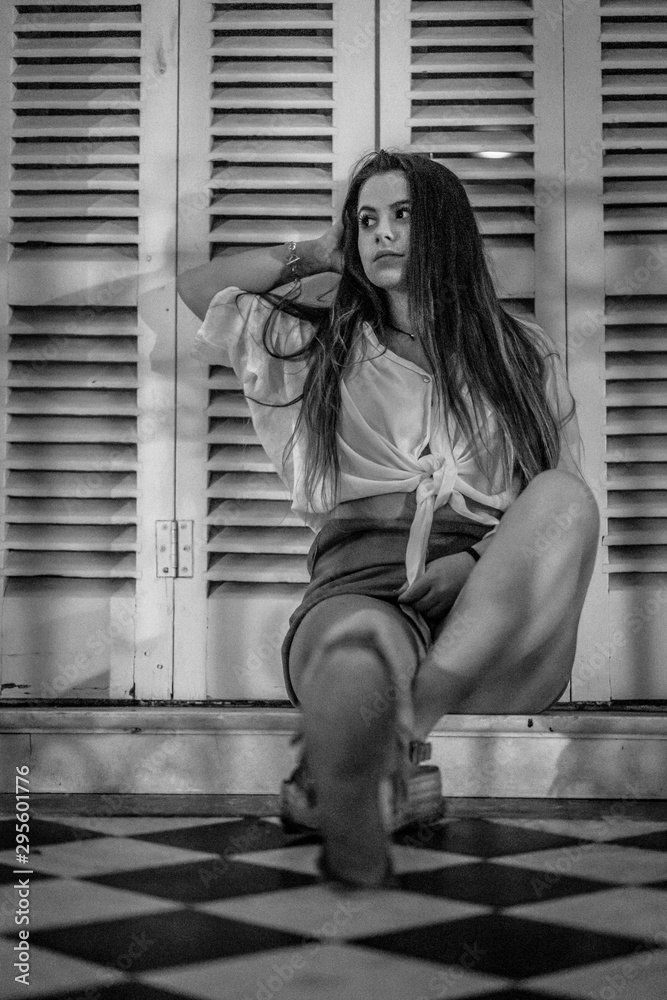 Lifestyle of a young smiling brunette sitting looking to the left, black and white photo Lifestyle of a young smiling brunette sitting looking to the left, black and white photo