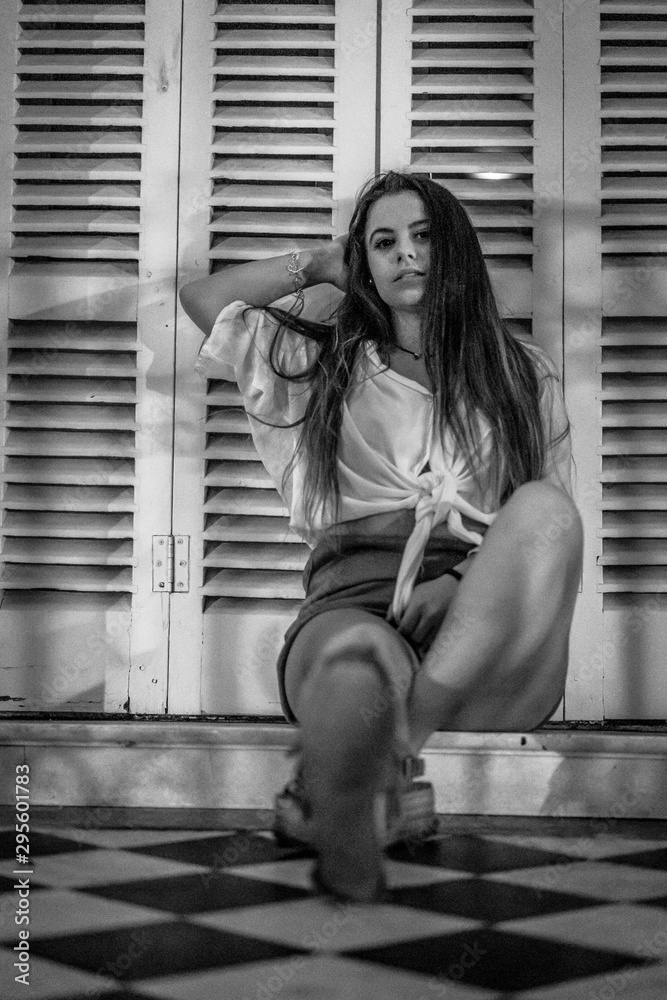 Lifestyle of a young smiling brunette sitting, black and white photo
