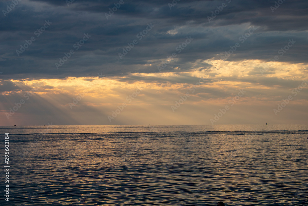 The rays of the sun make their way through gloomy clouds over the Black Sea