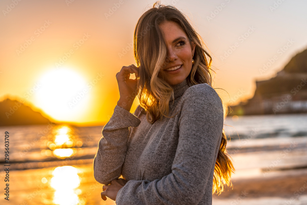 Naklejka premium Seksowny look w sesji Lifestyle blondynki w szarej sukience na zachodzie słońca