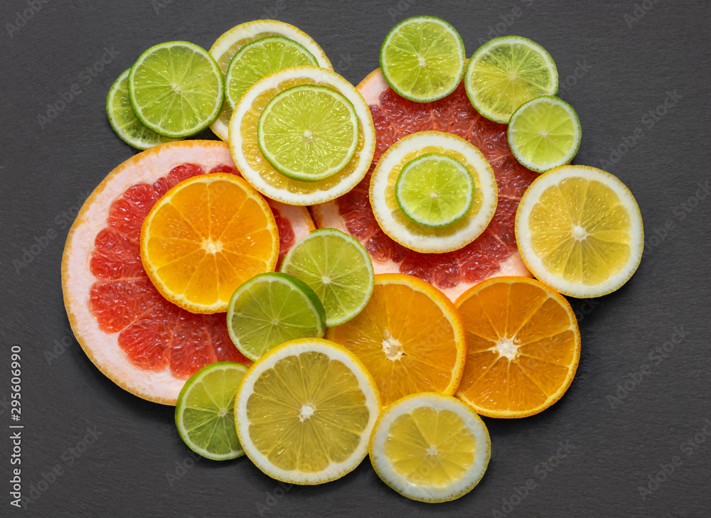 Fruit background. Sliced citrus fruit on a stone table. Flat lay, top view. Juicy ripe orange, tangerine, grapefruit, lime and lemon on a gray background Fruit background. Sliced citrus fruit on a stone table. Flat lay, top view. Juicy ripe orange, tangerine, grapefruit, lime and lemon on a gray background