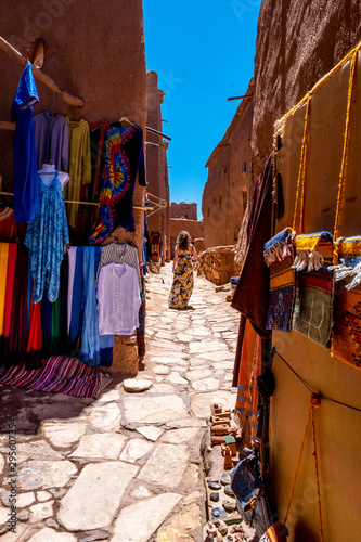 Woman in dress walking in street of the ancient city of Benhadou located in Morocco © ikuday