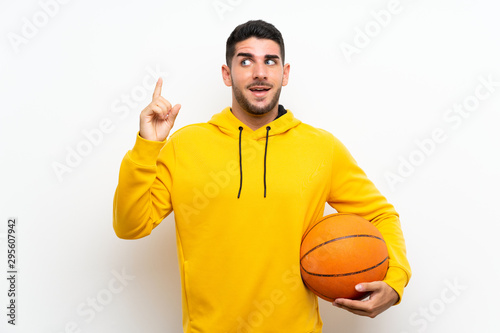 Handsome young basketball player man over isolated white wall intending to realizes the solution while lifting a finger up © luismolinero