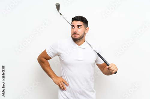 Handsome young golfer player man over isolated white background making doubts gesture while lifting the shoulders