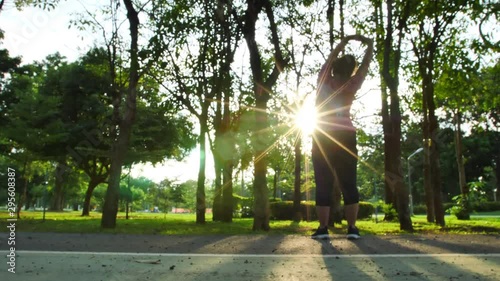 Slow Motion Rear view of women asian Warm up, stretch and run exercise in the park and evening sun. Good health and exercise