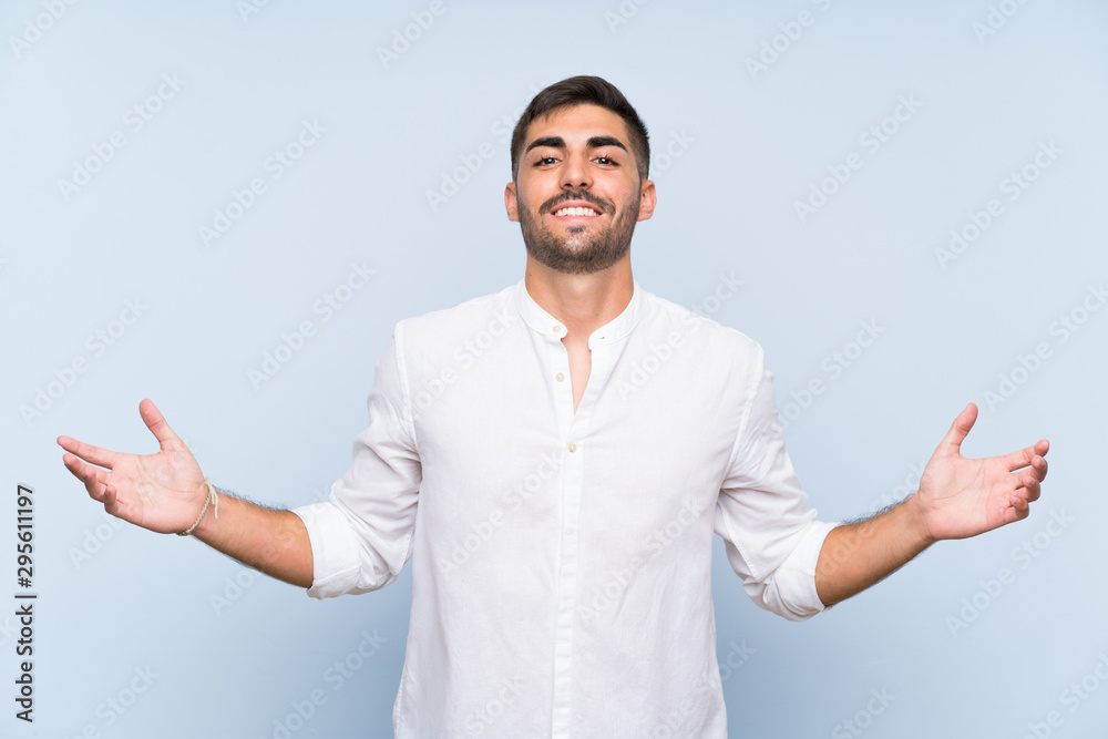 Handsome man with beard over isolated blue background smiling a lot Handsome man with beard over isolated blue background smiling a lot