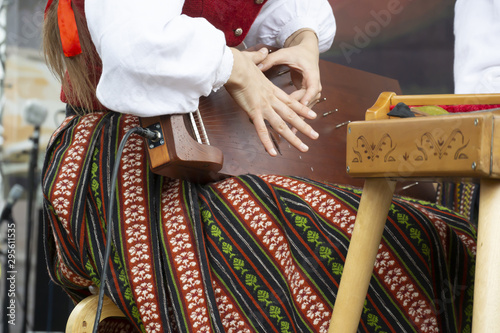 A young girl plays the kokle string instrument photo