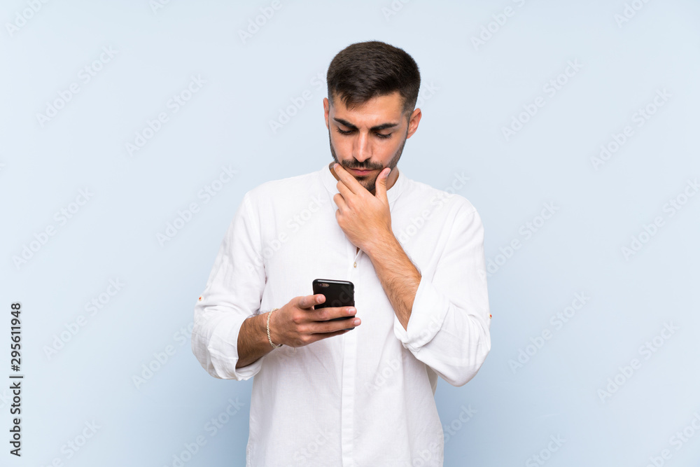 Handsome man with beard over isolated blue background thinking and sending a message Handsome man with beard over isolated blue background thinking and sending a message