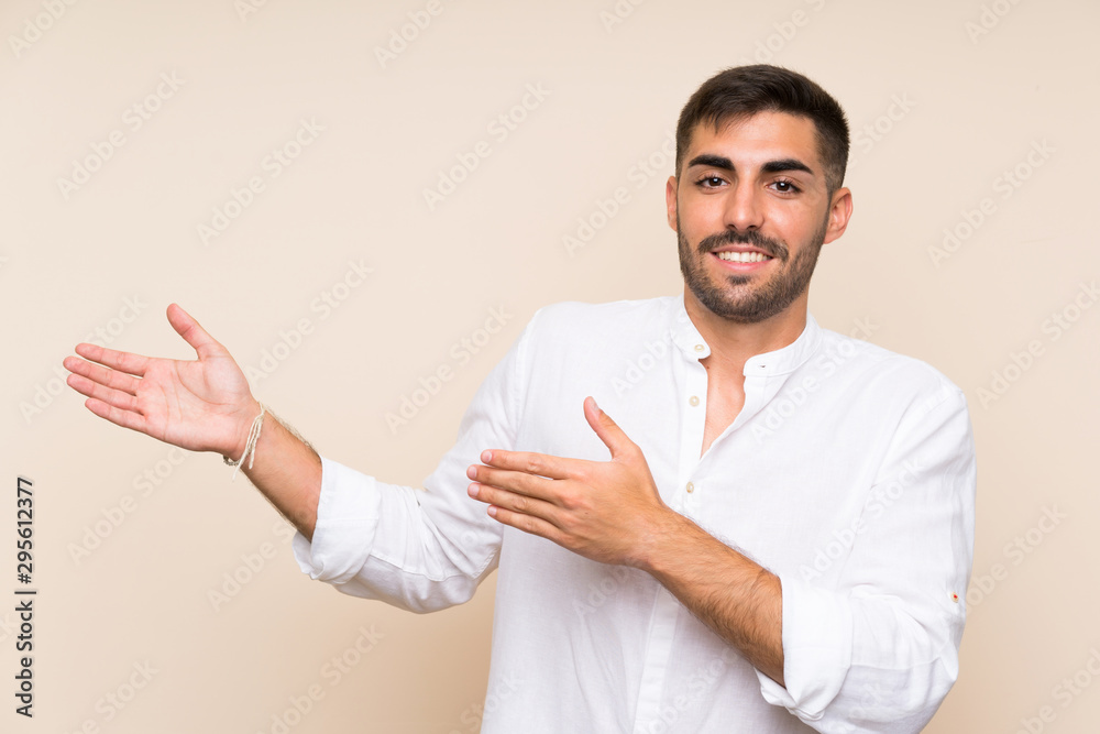 Handsome man with beard over isolated background extending hands to the side for inviting to come Handsome man with beard over isolated background extending hands to the side for inviting to come