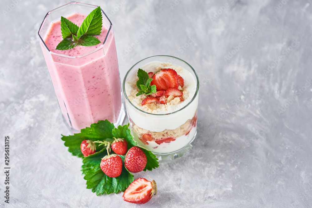 Strawberry smoothie in glass jar and fresh strawberries on a gray background Strawberry smoothie in glass jar and fresh strawberries on a gray background