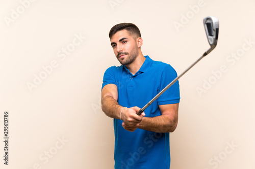 Young handsome golfer man over isolated background